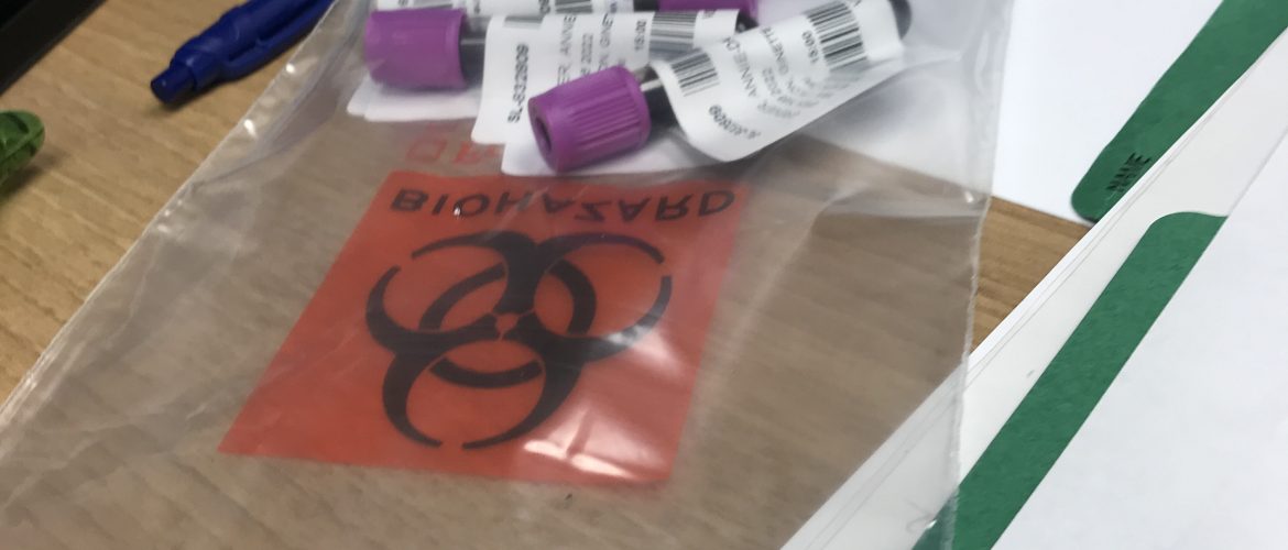 Des fioles de prises de sang dans un sac sur un bureau