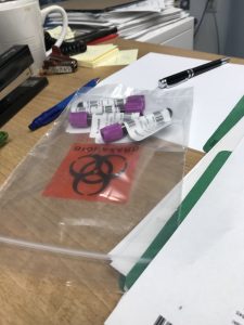 Des fioles de prises de sang dans un sac sur un bureau